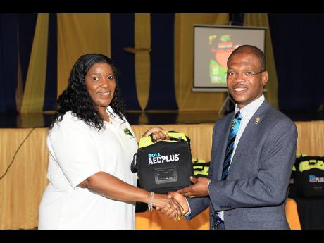 Karen Wilson-Robinson (left), Esq, vice-chair, Team Jamaica Bickle, presents one of the units to Dr Kevin Brown (right), president, University of Technology, Jamaica during the official handover ceremony held last Wednesday at the university’s Alfred San
