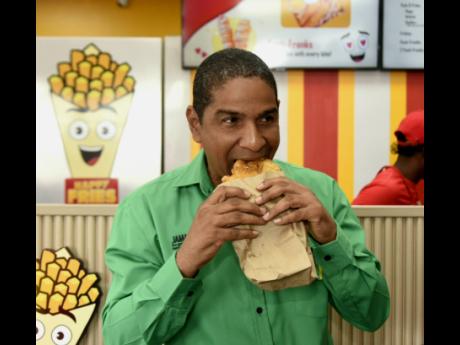 Mayor of Kingston Delroy Williams sinks his teeth into a freshly fried ‘fritta’, made with love at Happy Fries’ recent grand opening held at the food hub, located on Slipe Road.