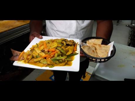 Portland businessman Peter Hall showing off a curried fish meal prepared by him.