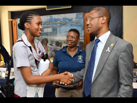 Dr Kevin Brown (right), president of the University of Technology, Jamaica, UTech greets Katherine Daye (left), sixth-form student at the St Andrew High School for Girls during the 2023 staging of the UTech open house. Looking on is Kerry-Ann White, direct