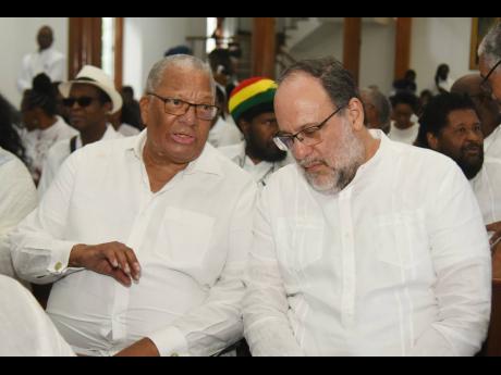 From left; Member of Parliament Peter Phillips and Opposition Leader Mark Golding in conversation at  the thanksgiving service for the late Kingsley ‘Ibo’ Cooper.