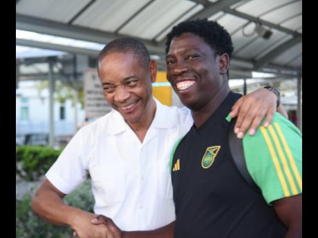 Jamaica Football Federation general secretary Dennis Chung (left) greets Reggae Girlz interim head coach  Xavier Gilbert at the Norman Manley International Airport yesterday shortly after the team arrived from Panama. The new-look Girlz put in a brave perf