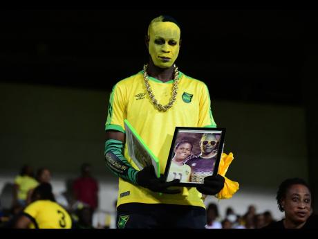 Reggae Tiger shows off framed photos of Reggae Girlz captain Khadija ‘Bunny’ Shaw during a World qualification fixture at Sabina Park last year.