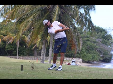 American Andrew Arft plays his tee shot on the picturesque number four hole at the Tryall Club on day one of the Jamaica Open.
