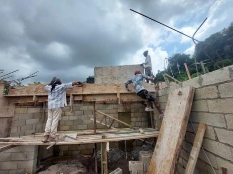 From left: Foreman Audley Dennie, Ras-Bauty Dennie and Johnoy Dennie continue working on a two-storey residential structure in Stony Hill, St Andrew, after Monday’s earthquake.