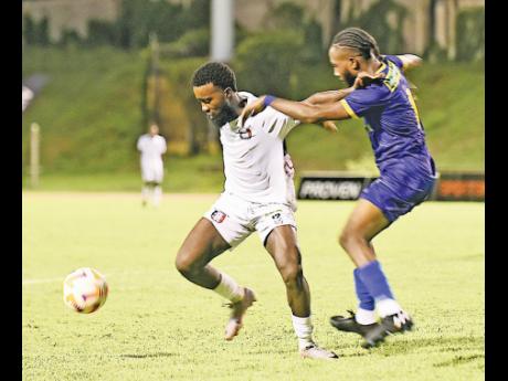  Arnett Gardens forward  Kimani Arbouine (left) shielding the ball from Molynes United’s Taraj Andrew’s during last night’s Wray and Nephew-sponsored Jamaica Premier League match at the Stadium East field. Arnett won 4-0.