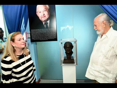 Barbara Henriquez and her brother, Joseph A. Matalon, look at the bust of their father, Aaron Matalon, after its unveiling at the University of the Commonwealth Caribbean (UCC)  Library Naming Ceremony to recognise Aaron Joseph Matalon for his role in the 