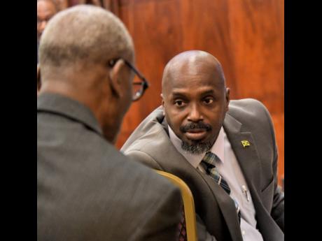 Richard Thompson (right), acting director general of the Office of Disaster Preparedness and Emergency Management, speaks with Local Government Minister Desmond McKenzie, who has Cabinet responsibility for the agency.