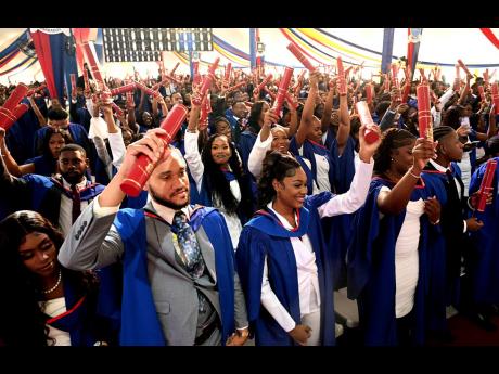 Valedictorian Aundrene Cameron (front row, centre), Bachelor of Laws with First Class Honours, celebrates with graduates at the University of the West Indies, Mona, graduation ceremony at UWI, yesterday.