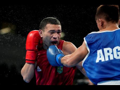 Brazil’s Michael Da Silva (left) and Argentina’s Ramon Quiroga fight in a men’s boxing 51kg semifinal bout at the Pan American Games in Santiago, Chile on Thursday, October 26, 2023. 
