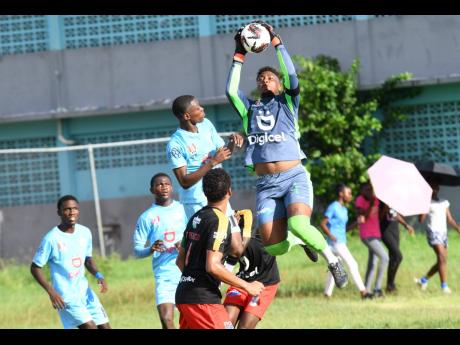 Mona High’s goalkeeper Akeem Bernard (right) goes high to make a save during  an  ISSA/Digicel Manning Cup football match against St Catherine High on Friday, October 20, 2023 in Spanish Town.
