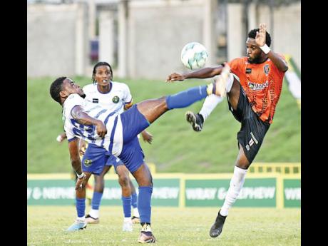 Vere United’s Suejay Graham (left) battles with  Anthony Nelson of Tivoli Gardens FC during yesterday’s Wray and Nephew Jamaica Premier League match at the Stadium East field. Vere won 2-1. 