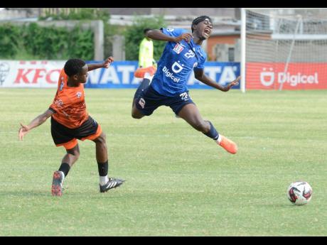 Jamaica College’s Renaldo Barett (right) is sent flying from a tacklefrom Tivoli Gardens’ Malachi Rose during their ISSA/Digicel Manning Cup quarterfinal round game at the Stadium East field yesterday.