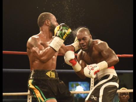 Sakima Mullings (left) lands a left hook to the face of Canadian, Phil Rose, during the final of the Wray and Nephwe Contender at the Mico University College in St Andrew on Wednesday July 26, 2017. 