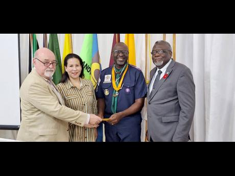 From left: Mark Kerr-Jarrett and his wife Anya present a cheque to Garth Russell, chief commissioner of the Scouts Association of Jamaica. Sharing the moment is Bishop Conrad Pitkin, custos of St James and president-designate of the St James Scouts Local A