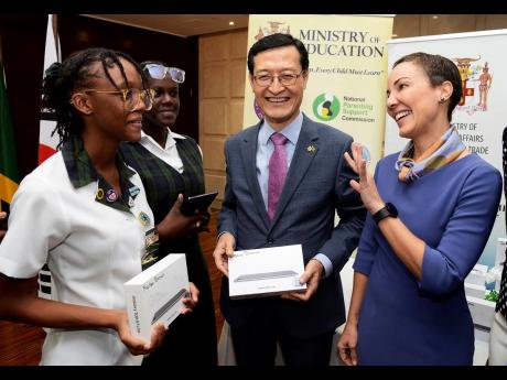 Senator Kamina Johnson-Smith (right), minister of foreign affairs and foreign trade, shares with Jadiel Lindsay (left), and Danielle Warren (2nd left), students at Meadowbrook High School, who received tablet computers which were donated by the government 
