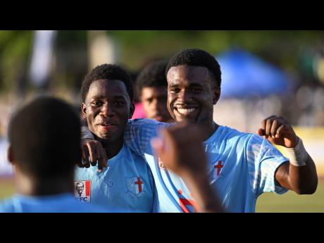 St George’s College’s Matthew Spence (back to camera) celebrates with Jhaheim Henry (left) and Malique Lorraine after pulling off a semi-final qualifying 1-1 draw against Jamaica College at the Ashenheim Stadium yesterday.