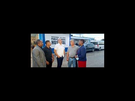 Health and Wellness Minister Dr Christopher Tufton (centre) grabs the attention of stakeholders in a discussion on what the entrance of the Savanna-la-Mar Public General Hospital will look like during a tour of the hospital on Thursday. Sharing in the disc