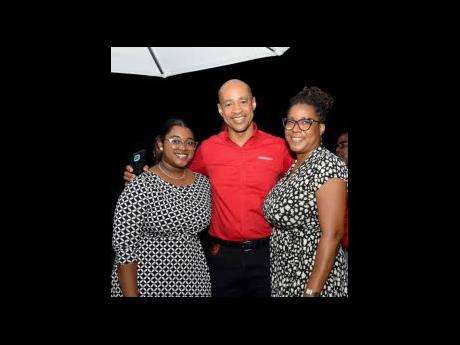 JMMB Bank’s Miguel Beckford is flanked by colour-coordinated duo Celina Campbell (left) and Audrey Dillon of Global Exchange.