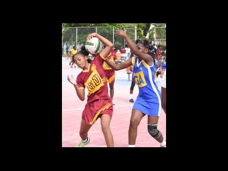 Wolmer’s Girls’ Lutonya Shelton (left) wrests possession from St Hugh’s High School’s Kheresha Pecco during action from the second round of the ISSA Schoolgirls’ Netball competition at the Leila Robinson Courts yesterday.