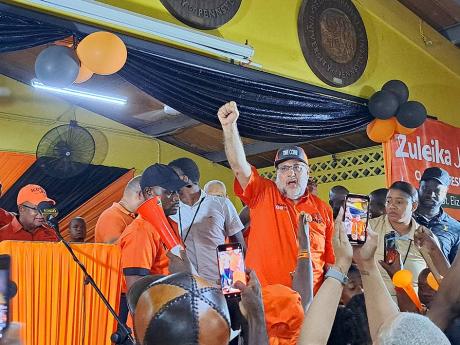 Opposition Leader and People’s National Party President Mark Golding gestures to the crowd while making his way on to the stage at a party meeting held at the St Elizabeth Technical High School.