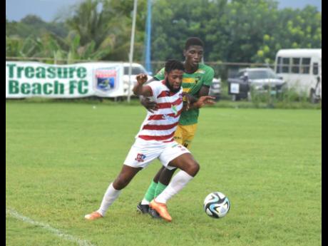 Dunbeholden’s Dean-Andre Thomas (left) and Treasure Beach FC’s Ryan Dwyer battle for the ball during their Wray and Nephew/Jamaica Premier League match at the STETHS  Sports Complex in  St Elizabeth yesterday. The game ended in a 0-0 draw.