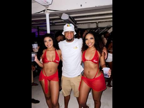 Dream Entertainment Event Manager Ron Burke poses with hostesses at the recent Blue Ibis Experience in Trinidad.