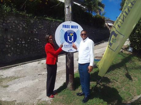 Dave Brown, member of parliament for Hanover Eastern,  and Deputy Mayor of Lucea Andria Dehaney Grant point to the free wi fi sign in Hanover. 