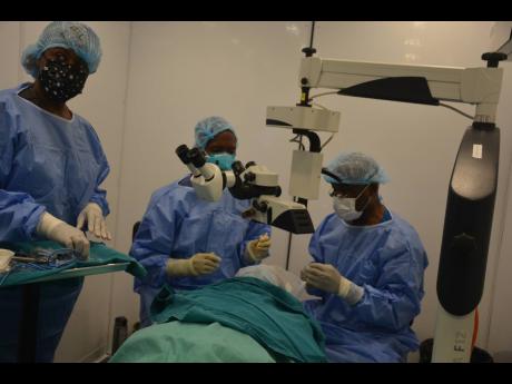 Doctors Giovanni Greaves (centre) and Basil Morgan (right) and nurse Kiana Williams performing the first of 13 eye surgeries in a makeshift state-of-the-art operating theatre on the grounds of the Cornwall Regional Hospital in Montego Bay on Monday. 