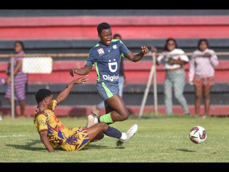 Nickoy Gayle (left), of St Andrew Technical, tackles Denzel McKenzie, of Mona High, during a Manning Cup quarter-final match at the Anthony Spaulding Sports Complex on November 10. Mona won 2-0.
