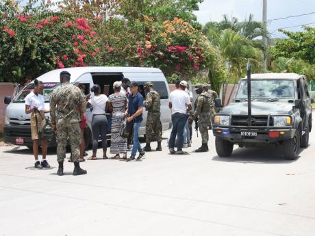 Passengers from a minibus being searched at a checkpoint at Wiltshire in Greenwood, St James by members of the Jamaica Defence Force (JDF) in this May photo.