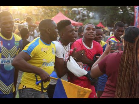 Photo by Lenox Aldred 
Clarendon College substitute goalkeeper Lydel Rodney (centre) is mobbed by players and supporters following their 4-3 penalty shootout win over Garvey Maceo in the ISSA/daCosta Cup semifinals at Glenmuir High yesterday.