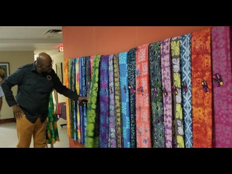 Harold Davis, deputy CEO at the Jamaica Business Development Corporation (JBDC), looks at some of the Jadire batik fabrics produced by former JBDC trainees. 