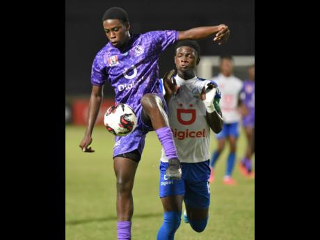 Jaheim McLean (left) of Kingston College controls the ball ahead of  Hydel Hydel High’s Dujuan Green during their Manning Cup semi-final at Sabina Park last Friday. Hydel won 5-4 on penalties.