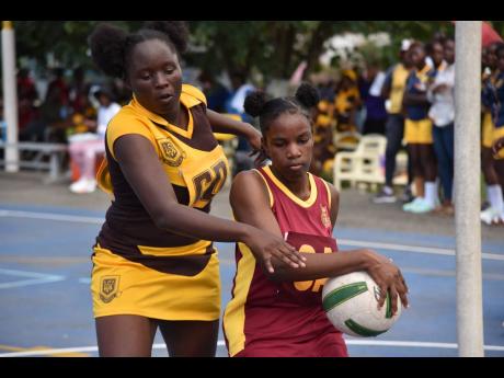 Taijahnae Gardener (left) of Manchester High keeps close to Jada Ricketts of Holmwood Technical during their ISSA rural schoolgirls senior netball match at the G.C. Foster College yesterday. Holmwood won 74-13.