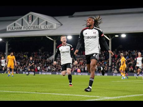 Fulham’s Alex Iwobi celebrates scoring their side’s first goal during the English Premier League  match between Wolverhampton Wanderers and Fulham at Craven Cottage, London yesterday.