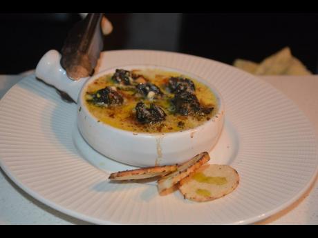Elevate your taste buds with the exquisite flavours of Escargot in garlic-herb butter.
