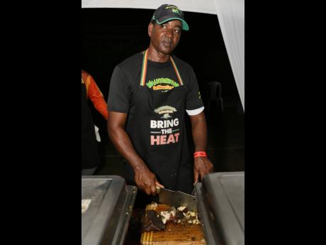 Bringing the heat, Sheriff style, Wayne King slices the succulent curried jerk pork.