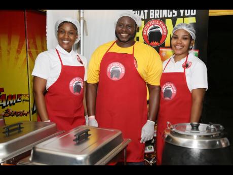 Members of the Spicy Hill Farms team (from left) Rochelle Hudson, David Meek, and Adijah Reid presented the Sunday dinner line-up of curried chicken, jerked chicken with white rice, and chicken soup or mannish water to the VIP section of Kingston Curry Fes