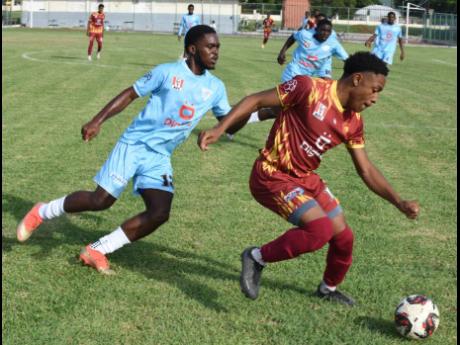 Wolmer’s Boys’ School’s Dante Dacres (right) gets past St Catherine High School’s Akeem Brown during their ISSA Walker Cup Knockout football game at the Mico University College on November 21.
