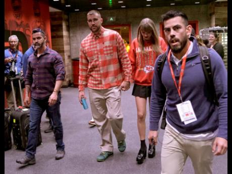 Kansas City Chiefs tight end Travis Kelce, centre left, and singer Taylor Swift leave Arrowhead stadium after an NFL football game between the Chiefs and the Los Angeles Chargers in Kansas City, Mo., on October 22.