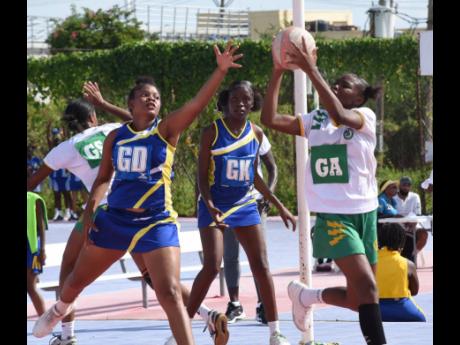 Goal attack Kevandra Blake (right) of  St Jago High collects a pass while goal defence Faith Gordon (left) and goal keeper Crystal Nicholson (centre) of Gaynstead High look on during their ISSA urban schoolgirls’ senior netball match at the Leila Robinso