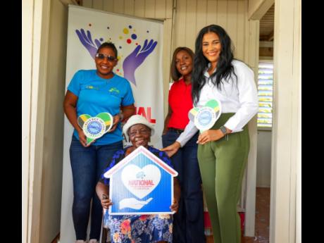 Enid Walters-Johnson (second left) is all smiles during the handover ceremony for her new home. Sharing in the moment are (from left) Marsha Burrell-Rose, marketing and development manager, Food For The Poor Jamaica; Winsome Exell, customer service manager