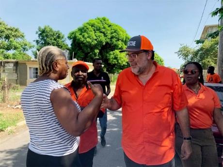 People's National Party President Mark Golding (second right), accompanied by Jason Cummings (second left), councillor caretaker for the Rose Hall division, and Rochell Rochell Reid-Knot (right), caretaker for St James East Central, engages a resident of t