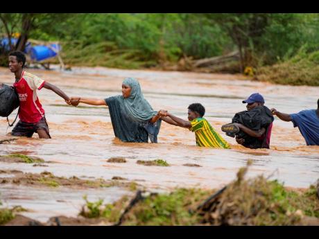  Residents crossing a road damaged during flooding in Tula, Tana River county in Kenya.