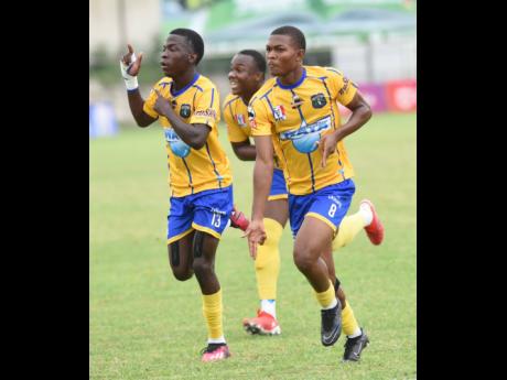 Members of the Clarendon College team celebrate after scoring against Hydel High during their Champions Cup semi- final match at the Anthony Spaulding Sports Complex on Tuesday. 