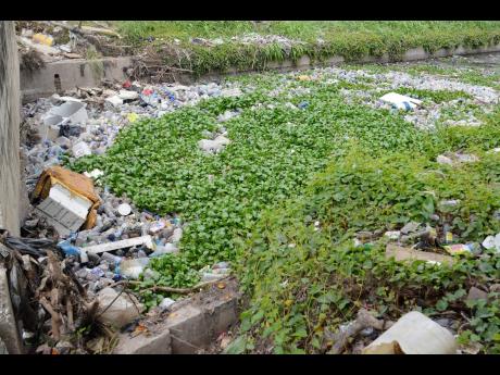 A blocked community drain results in a pile-up of debris. People are asked to play their part in ensuring that dengue cases are minimised by monitoring water-storage containers for mosquito breeding; keeping surroundings free of debris; and destroying or t