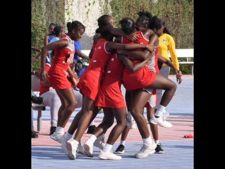 Members of the junior netball team from The Queen’s School celebrate after their win over defending champions St Hugh’s High in the ISSA urban schoolgirls semi-final  at the Leila Robinson Courts yesterday.