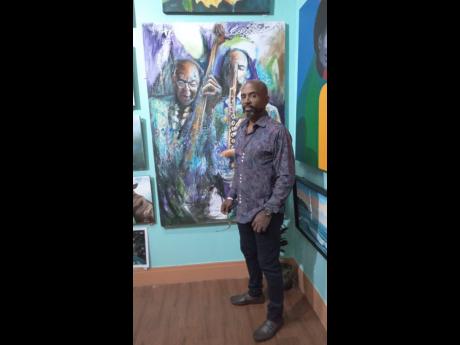 Mark Cameron stands in front of one of his paintings. 
