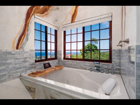 A whirlpool spa tub embraced by captivating Venetian marble plaster walls, offering a breathtaking view of the sea.